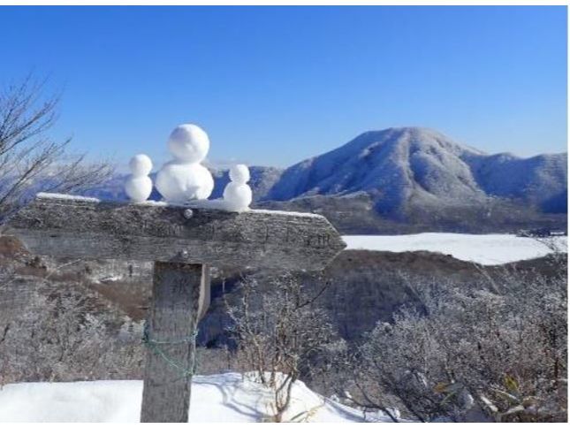 かわいい雪だるまの鍬柄山標識と大沼越しの赤城山遠望